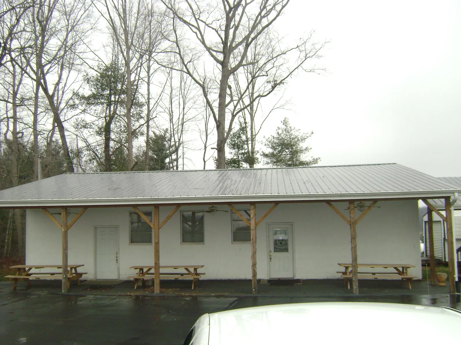Gray metal roof over a block building with a timber post porch in Henrieville