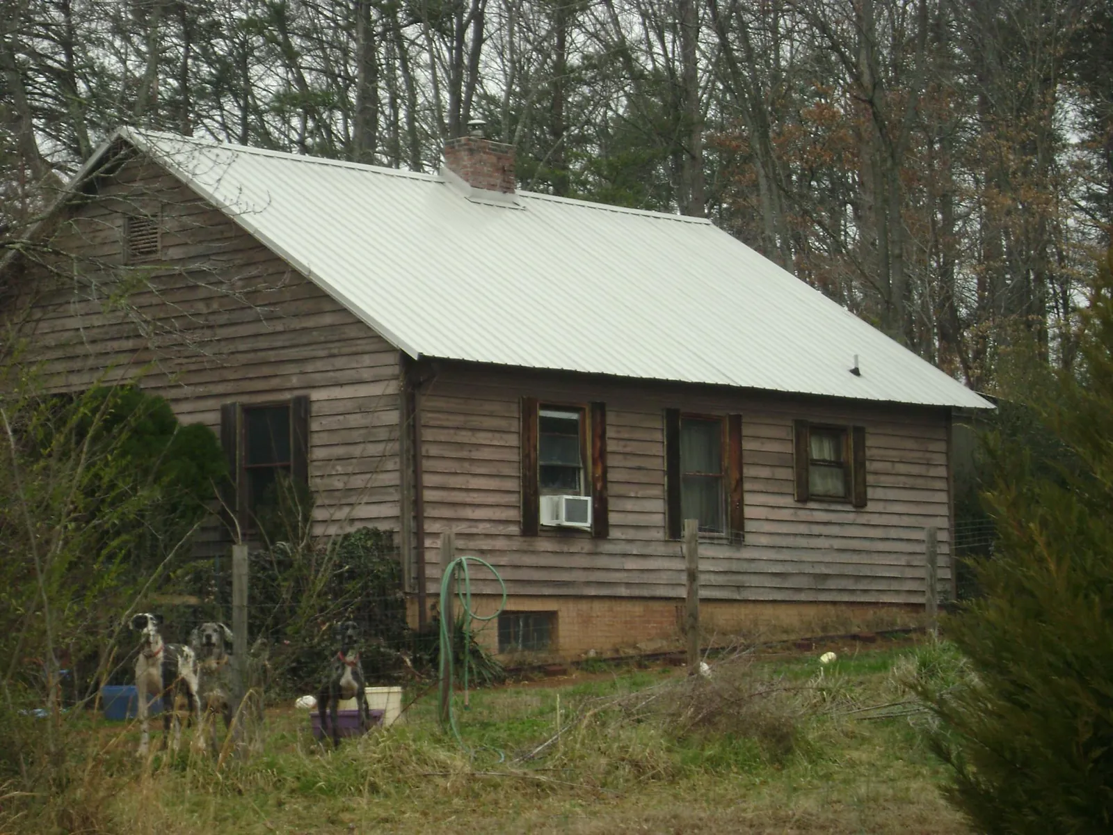 White metal roof on an old wood sided farmhouse, from a Metal Roof Installation job in Henrieville